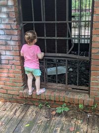 Girl standing against brick wall