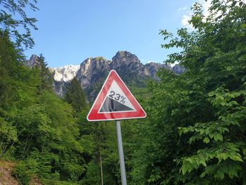 Information sign by road against sky