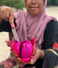 Midsection of woman holding fruit