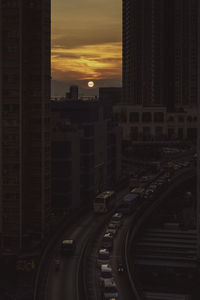 High angle view of street amidst buildings in city during sunset
