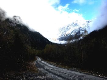 Road amidst trees against sky