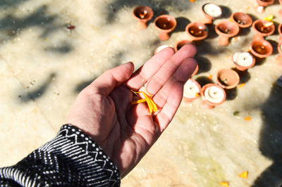 Close-up of hand holding a flower petal as an offering in swayambunath temple