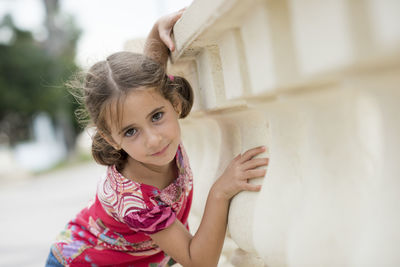 Portrait of smiling cute girl leaning on bannister