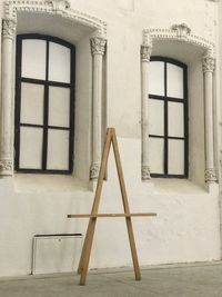 Low angle view of closed window of building and standing frame of the painting