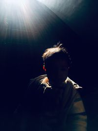 Silhouette boy standing in darkroom