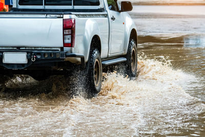 Pickup truck passing through flooded road. driving car on flooded road during flood.
