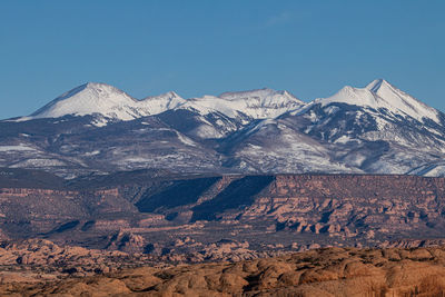 Full frame panoramic view of rugged terrain with snow capped mountains in the background