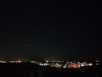 Illuminated city against sky at night