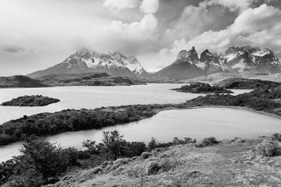 Scenic view of mountains and lake against cloudy sky