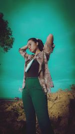 Young woman looking away while standing on beach