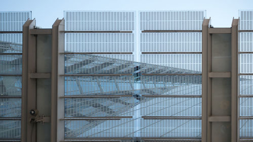 Modern building against sky seen through glass window