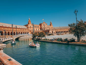 Boats in canal along buildings