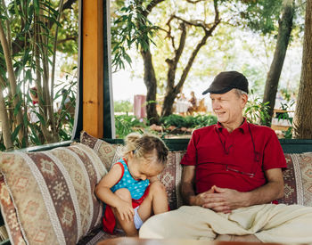  senior man sitting with granddaughter in garden