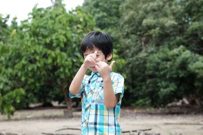 Boy gesturing while playing in park