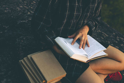 Midsection of person reading book