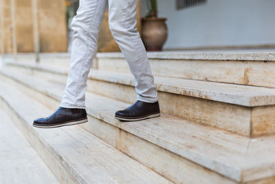 Low section of man walking on staircase