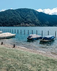 Boats moored in lake against sky