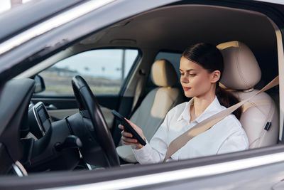 Portrait of young woman sitting in car