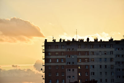 Residential buildings against sky during sunset