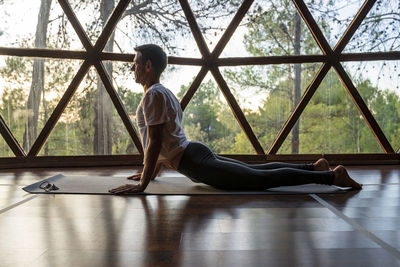 Mature man practicing yoga on mat at health spa