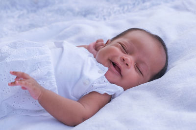 Baby girl lying on bed