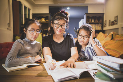 Smiling teacher teaching girls at home