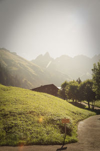 Scenic view of field by mountains against sky