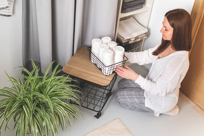 High angle view of woman sitting on bed at home