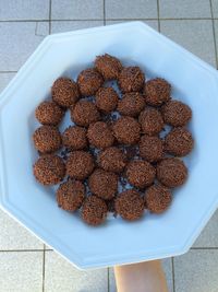 Cropped image of hand holding brigadeiros in plate