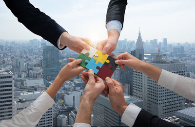 Cropped hand of man holding jigsaw piece