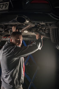 Portrait of male mechanic repairing car at auto repair shop