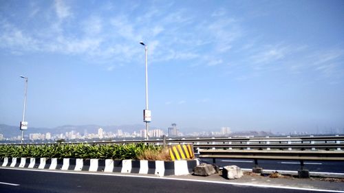 View of bridge over street against blue sky