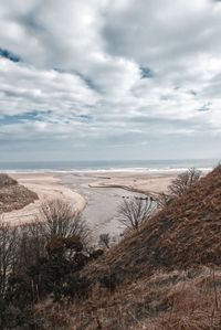 View of beach against cloudy sky