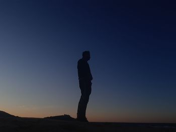 Silhouette man standing against clear sky during sunset