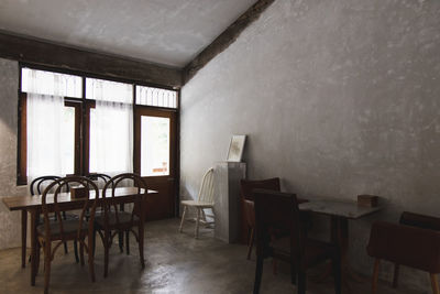 Empty chairs and table against wall at home