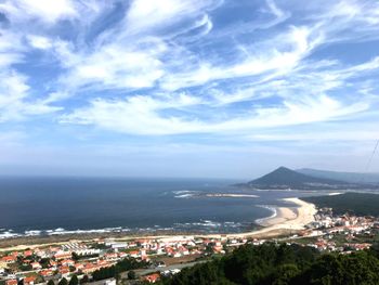 High angle view of city by sea against sky