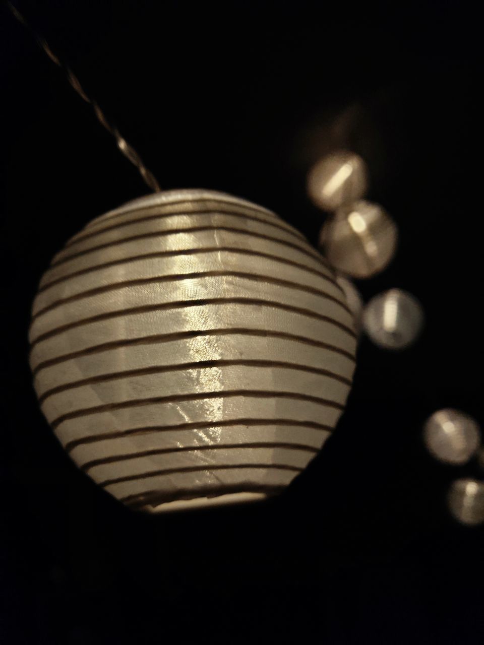 CLOSE-UP OF LIGHT BULB AGAINST BLACK BACKGROUND