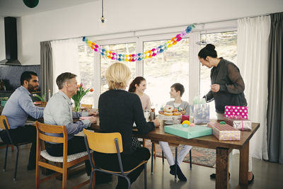 Multi-generation family enjoying food at birthday party