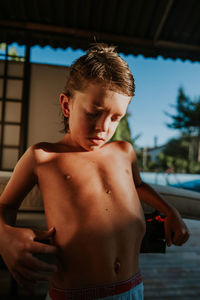 Full length of shirtless boy looking at camera