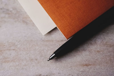 Close-up of pen with diary on table