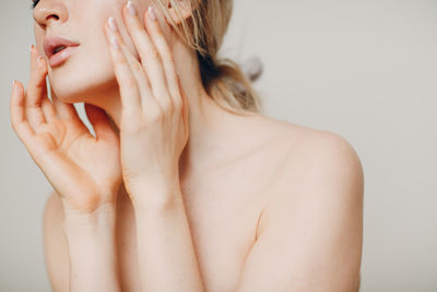 Close-up of shirtless young woman against white background