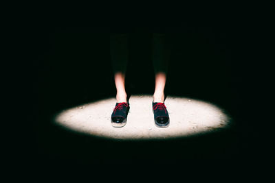 Low section of person standing in spotlight