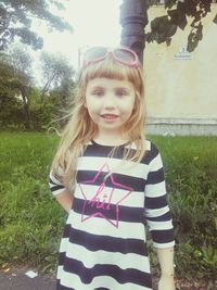 Portrait of smiling girl standing in lawn