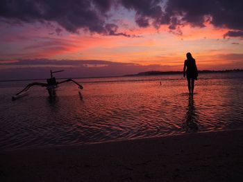 Silhouette man standing on beach against sky during sunset