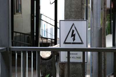 Warning signs for high voltage areas, mounted on lamp posts in the building