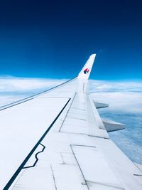 Airplane flying over clouds against blue sky