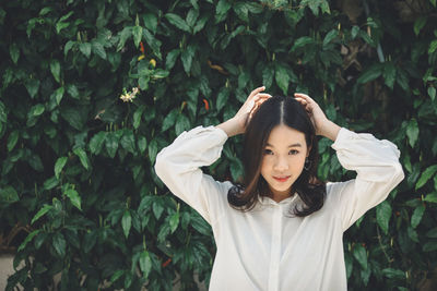 Portrait of young woman standing in park