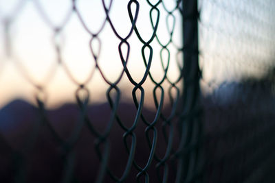 Close-up of chainlink fence against sky