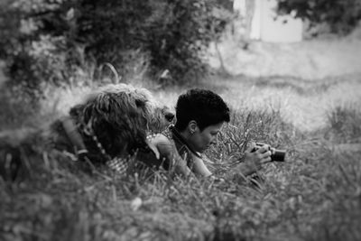 Woman playing with dog on grassy field