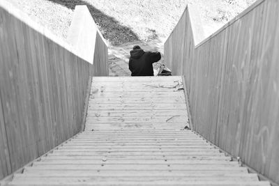 Woman sitting on retaining wall